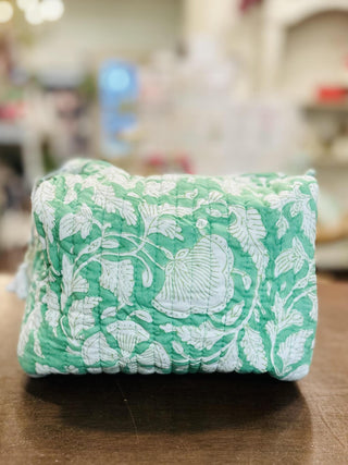 Green Gardenia quilted tote bag with matching makeup pouch

Quilted green floral tote bag with striped handles and zipper pouch

Green floral quilted tote bag filled with yellow tissue paper

Lightweight quilted tote bag with botanical print and makeup bag