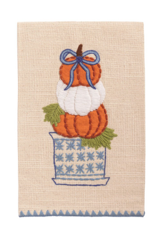 Natural cotton slub hand towel with stacked pumpkin topiary appliqué in a blue planter, embroidered details, blue bow, and blue triangle embroidered hem.