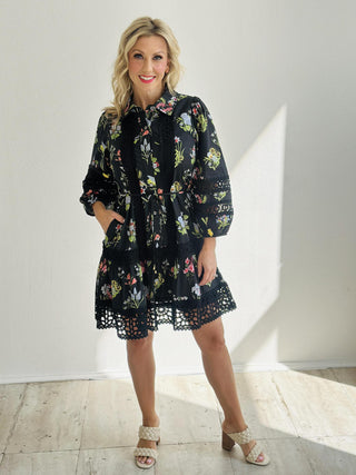 Woman wearing Kendra Dress, black floral mini dress with crochet lace trim

Kendra Dress featuring multi-floral print with button-front closure

Mini dress with puff sleeves, crochet accents, and ruffle hemline

Black floral print dress with ¾ elasticated sleeves and side pockets
