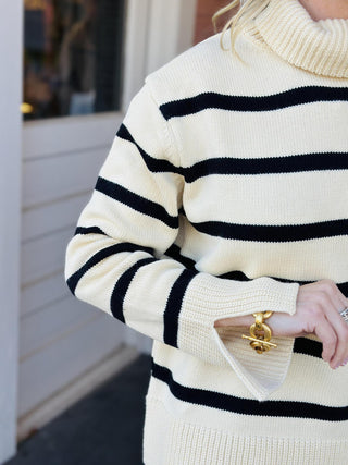 Cream and black striped turtleneck Nylah Sweater on model

Women’s striped turtleneck sweater with long sleeves and split cuffs

Neutral stripe cozy knit turtleneck sweater for fall and winter

Cream sweater with black stripes and relaxed fit turtleneck