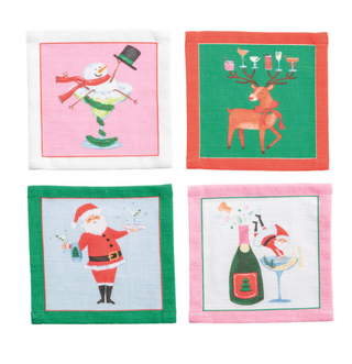 Set of four cotton holiday cocktail napkins featuring festive Christmas illustrations including a snowman cocktail, Santa, reindeer, and champagne celebration.