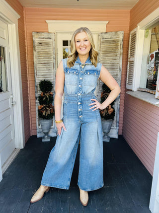 Woman wearing sleeveless wide-leg denim jumpsuit

Light wash denim jumpsuit with button front and wide legs

Collared sleeveless denim jumpsuit with pleats

Snow washed denim jumpsuit styled with boots

Wide leg chambray jumpsuit with front pockets