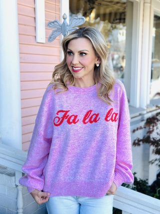 Pink “Fa La La” holiday sweater with red lettering

Bubblegum pink Christmas sweater with festive script

Cozy pink “Fa La La” knit pullover for the holidays