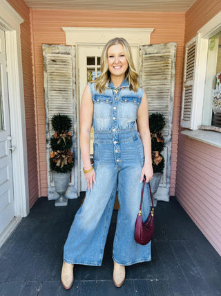 Woman wearing sleeveless wide-leg denim jumpsuit

Light wash denim jumpsuit with button front and wide legs

Collared sleeveless denim jumpsuit with pleats

Snow washed denim jumpsuit styled with boots

Wide leg chambray jumpsuit with front pockets