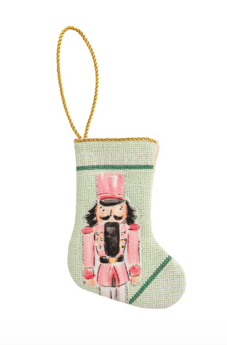 Mini Nutcracker Stockings featuring colorful needlepoint nutcracker designs, canvas backing, and cotton cord hanging loops.