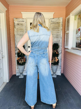 Woman wearing sleeveless wide-leg denim jumpsuit

Light wash denim jumpsuit with button front and wide legs

Collared sleeveless denim jumpsuit with pleats

Snow washed denim jumpsuit styled with boots

Wide leg chambray jumpsuit with front pockets
