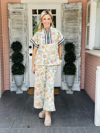 The Palmer Set featuring a soft floral print, zip-front collar detail, and matching wide leg pants with contrast side trim.