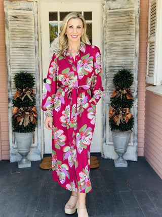 "Ava Center Stage Plum Dress with bold floral print, button front, and tie waist"

"Long sleeve plum midi dress with oversized pink and green floral pattern and belted waist"

"Women’s floral shirt dress in plum with button-down front, tie belt, and flowy silhouette"
