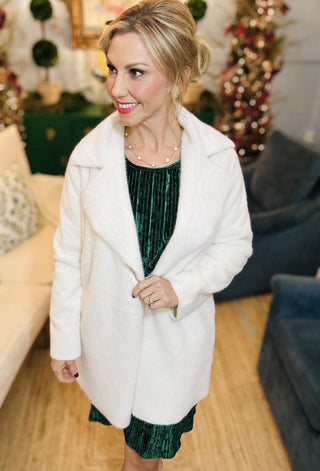 “Woman wearing ivory faux fur coat with oversized collar”

“Ellianna faux fur coat in cream with tailored silhouette”

“Soft ivory faux fur coat styled over a dress”

“Chic winter coat with plush texture and wide lapel collar”