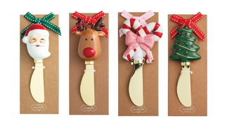 Whimsy Christmas Spreaders featuring brass-plated stainless steel blades with hand-painted holiday handles in Santa, reindeer, candy canes, and Christmas tree designs.