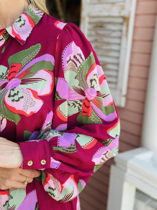 "Ava Center Stage Plum Dress with bold floral print, button front, and tie waist"

"Long sleeve plum midi dress with oversized pink and green floral pattern and belted waist"

"Women’s floral shirt dress in plum with button-down front, tie belt, and flowy silhouette"