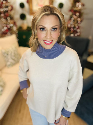 Neutral knit sweater with blue ribbed turtleneck and cuffs

Bethany Sweater Top with contrast blue neckline and sleeves

Long sleeve beige pullover sweater with ribbed details