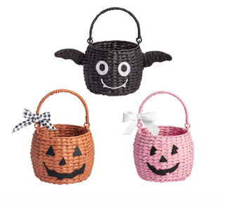Woven seagrass Halloween treat baskets featuring pumpkin, ghost, and pink jack-o'-lantern designs with felt facial details and decorative ribbon bows.