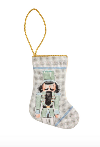 Mini Nutcracker Stockings featuring colorful needlepoint nutcracker designs, canvas backing, and cotton cord hanging loops.