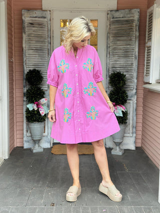 Ivy Jane Evie Dress in bright pink cotton with turquoise blocked floral embroidery, puff sleeves, pintuck front, and button-down design.