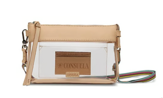 Consuela Diego Clear Midtown Crossbody featuring a transparent body, natural leather trim, zip-top closure, and a colorful adjustable woven crossbody strap.