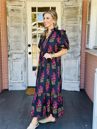Black floral puff sleeve dress with pink and mustard blooms

Elora Dress in black featuring ruffled sleeves and floral print

Black tiered floral dress with ruffle collar and short sleeves